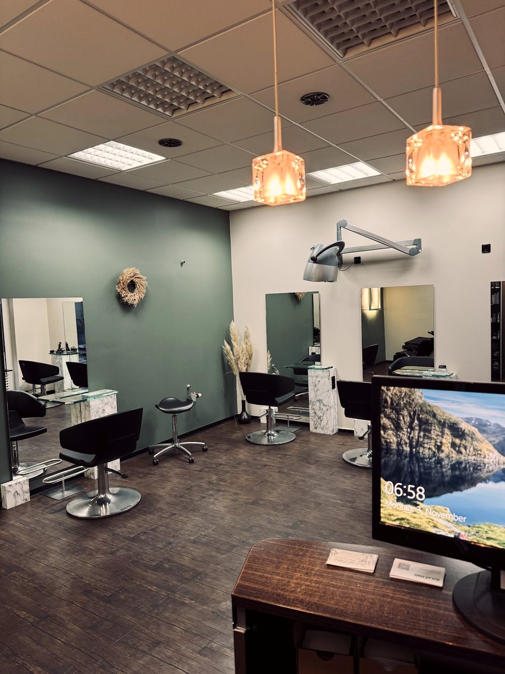 Salon Art of Hair in Joachimsthal: salbeigrüne Wand, Spiegelplätze und kupferne Hängelampen